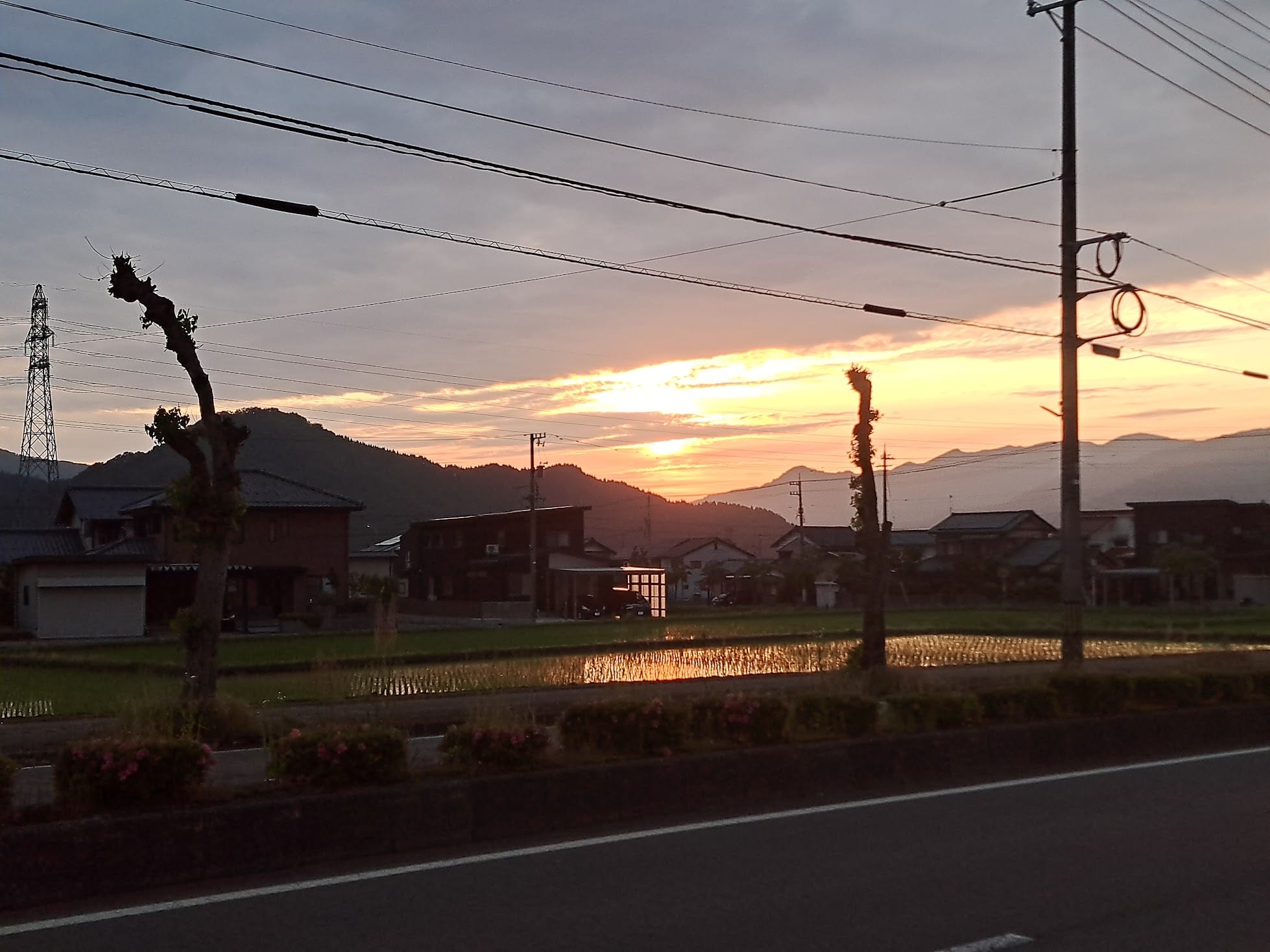 Sunset over the mountains and reflected in a race paddy field.
