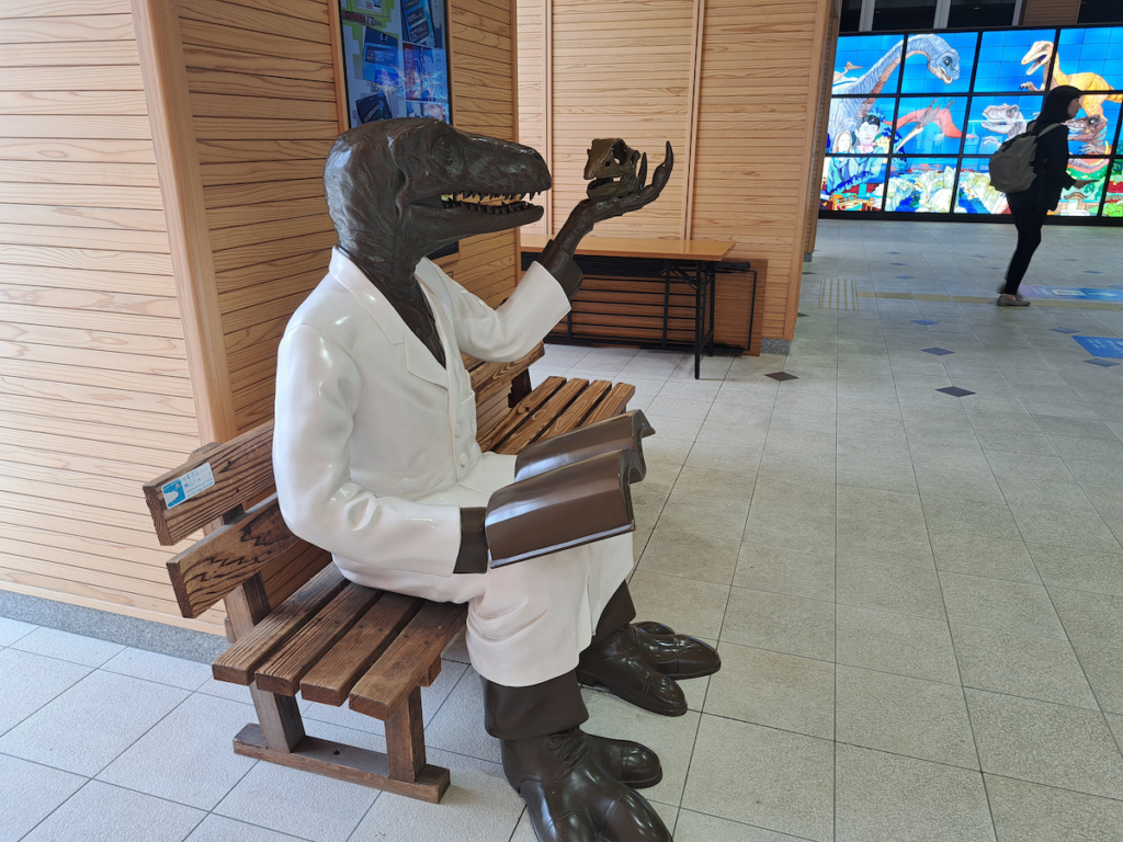 A dinosaur figure in a white coat